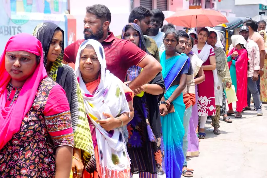 People wait in a queue under hot sun to cast their vote at a polling booth of Subbarao Nagar municipal school in Rajamahendravaram on Monday.  - A.MANIKANTA KUMAR