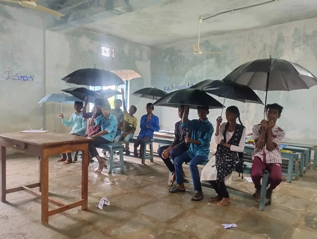 Mancherial: Students protest leaking building by holding umbrellas in classrooms