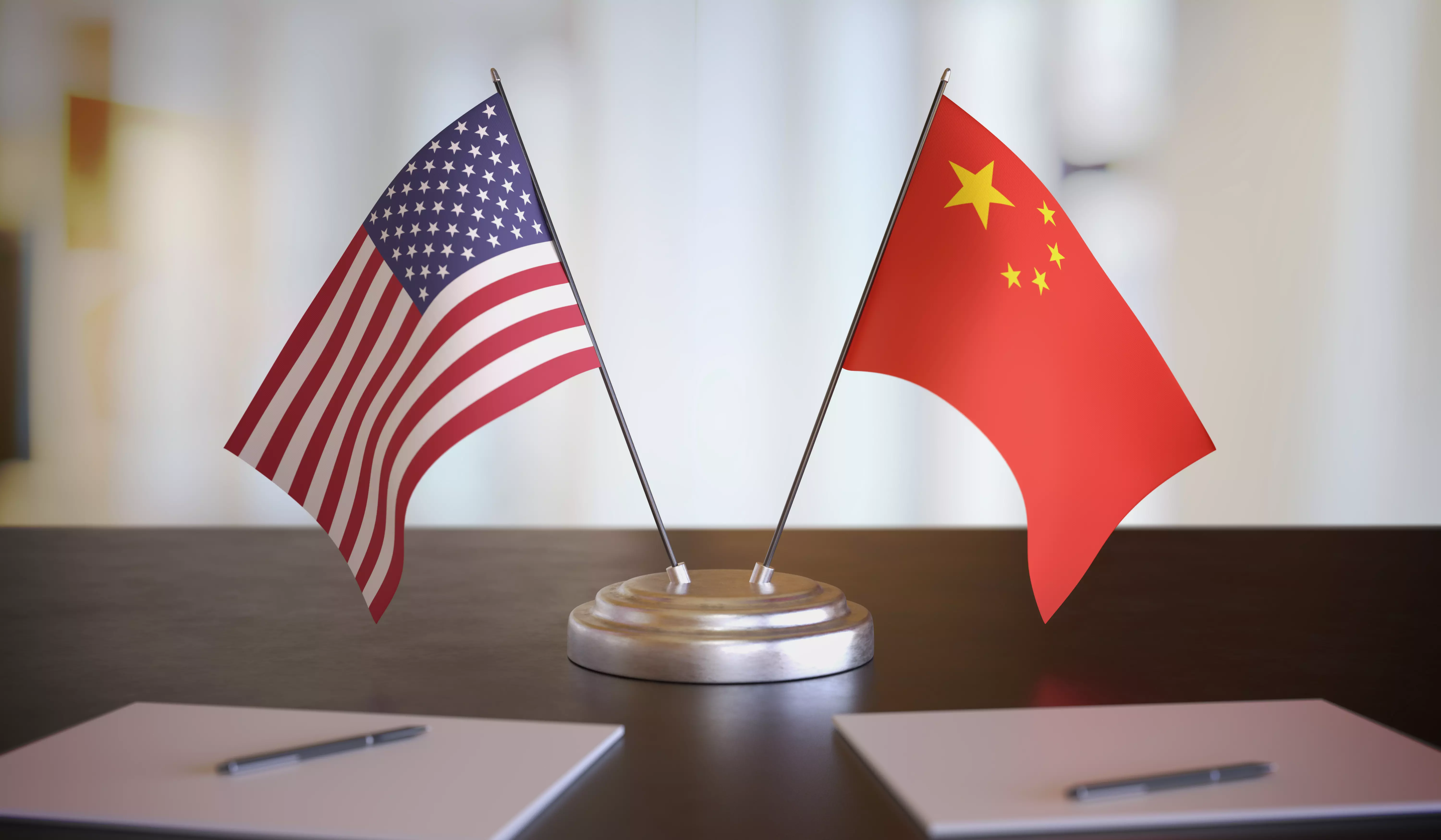 flags are placed on a desk with a pen and paper